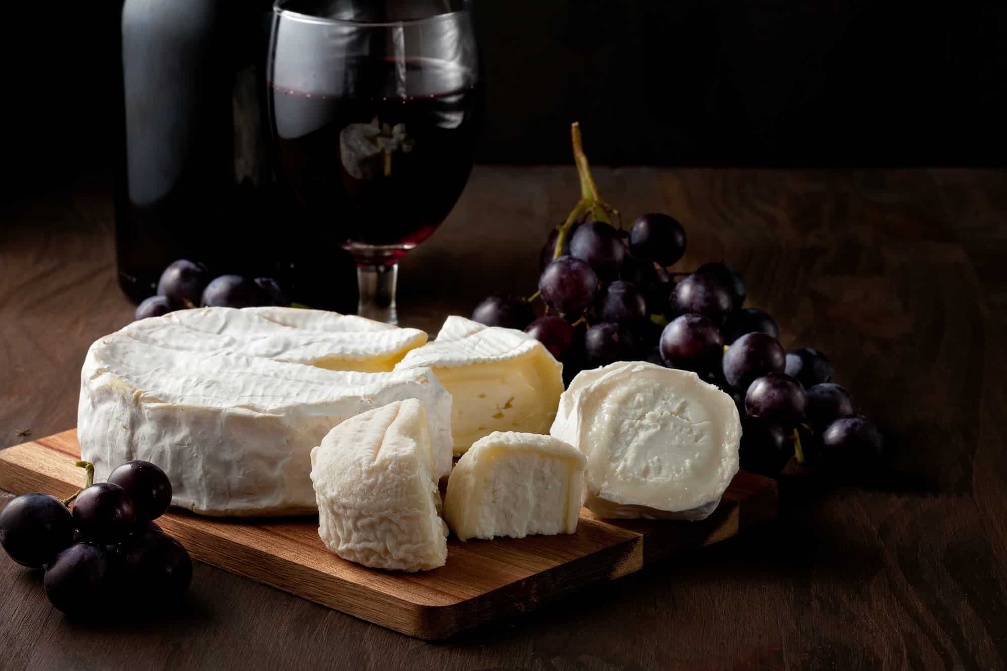 Variety of different cheese with wine and fruits